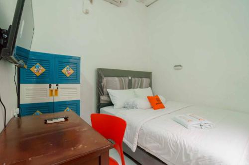 西冷KoolKost Syariah @ Citraland Puri Serang的客房设有两张床、一张桌子和一张书桌。