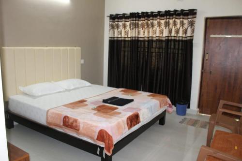 戈卡尔纳Hope villa homestay的一间卧室配有床和带窗帘的窗户