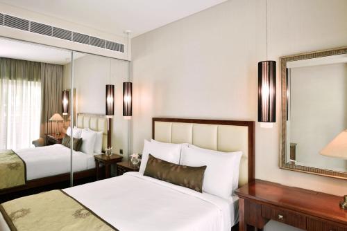浦那普纳万豪套房酒店的酒店客房,设有两张床和镜子