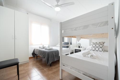 圣维森特德尔拉斯佩奇Villa Mimosa San Vicente del Raspeig的白色卧室设有两张双层床和一张桌子