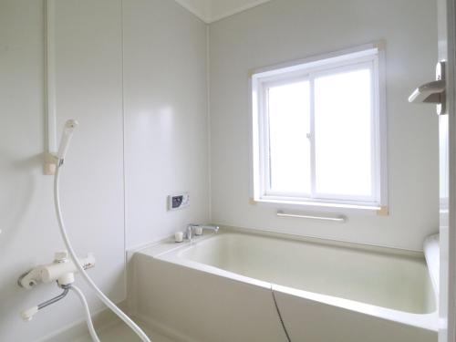 仙北noukanoyado seisetsukan的带窗户的浴室内的白色浴缸