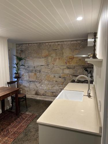 霍巴特Lumeah - Servant Quarters的一个带水槽和石墙的厨房