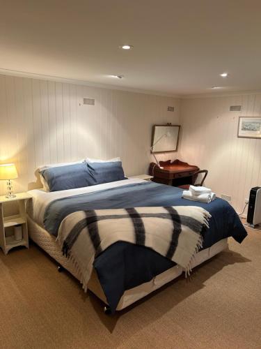 霍巴特Lumeah - Servant Quarters的一间卧室配有一张大床和一张桌子
