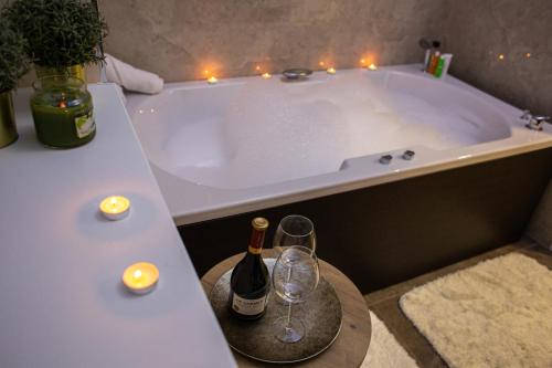贝尔格莱德Galaxy Apartments的浴缸配有一瓶葡萄酒和两杯酒