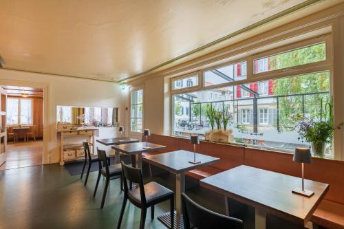 海登Linde Heiden Swiss Quality Hotel的餐厅设有桌椅和窗户。