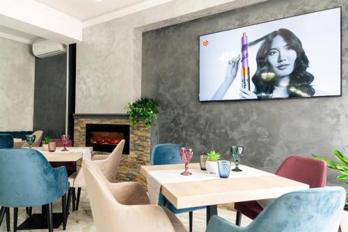 奥尔绍瓦Vega resort Restaurant & Lodge的一间带桌椅的餐厅以及墙上的电视