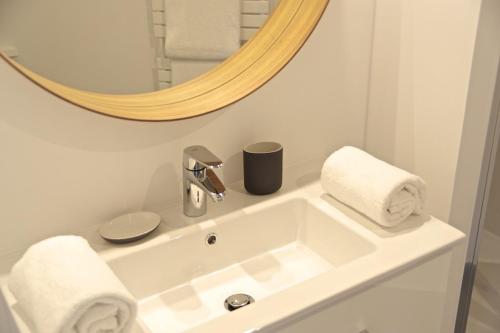 波尔多Chartres - Appartement 1 chambre avec ascenseur的浴室设有白色水槽和镜子