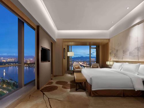福州福州融侨皇冠假日酒店的一间卧室设有一张大床和一个大窗户