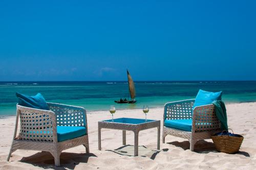迪亚尼海滩Diamonds Leisure Beach & Golf Resort的海滩上的两把椅子和一张桌子