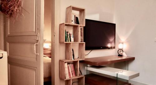 波尔多Koko & Baobab的一间带电视和书架的客厅
