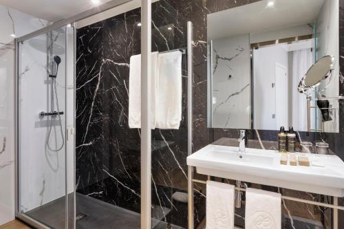 塞维利亚艾克斯塞维利亚玛卡瑞纳酒店的一间带水槽和淋浴的浴室