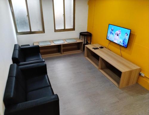 台北星空间 Star co-living space的一间设有两把椅子和一台平面电视的等候室