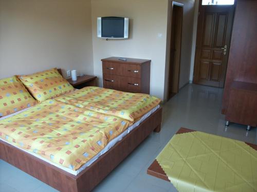波达雅斯卡Penzion Karen的卧室配有一张床,墙上配有电视。