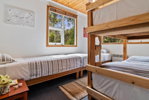 Alonnah曼荼罗布鲁尼岛度假屋的一间卧室设有两张双层床和一扇窗户。