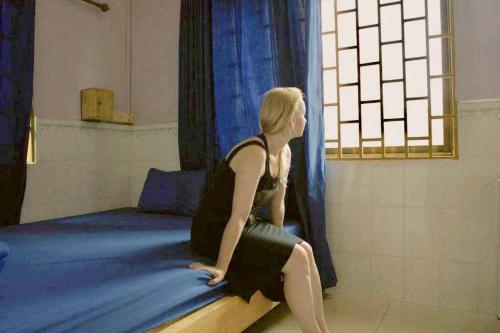 暹粒Hostel Goen -Japanese hostel-的坐在床上的女人