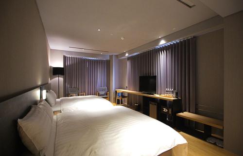 嘉义市嘉义观止饭店的卧室配有一张白色大床和电视。