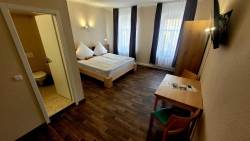 森夫滕贝格Hotel Due Fratelli的小房间设有一张床和一张桌子