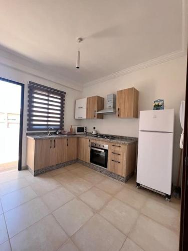 马拉喀什Nour casa de hoy的厨房配有木制橱柜和白色冰箱。