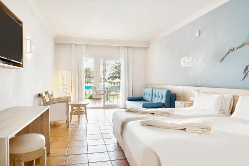 阿加迪尔Iberostar Founty Beach All Inclusive的酒店客房配有两张床和一张书桌