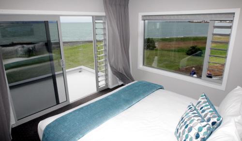 纳皮尔东码头酒店的一间卧室设有一张床和一个大窗户