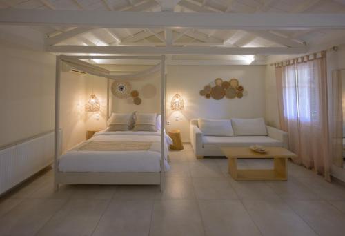 米蒂利尼奥基斯优雅小别墅酒店的一间卧室配有一张床、一张沙发和一张桌子