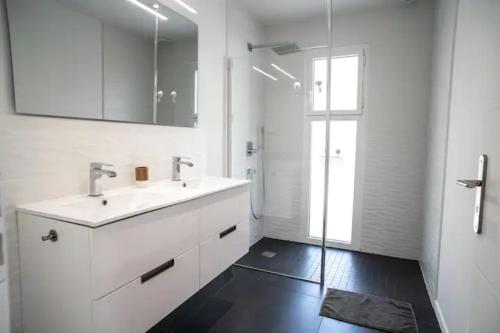 居让梅斯特拉La villa Sirelis piscine et spa的白色的浴室设有水槽和淋浴。