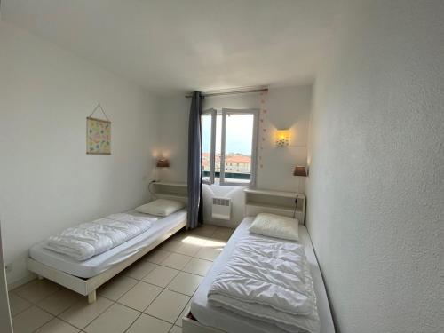 布科·莱斯白老城Appartement Vieux-Boucau-les-Bains, 3 pièces, 6 personnes - FR-1-379-75的带窗户的客房内的两张床