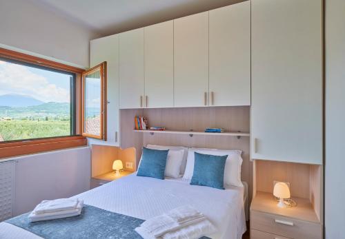 巴多利诺Appartamento Noal的一间卧室配有一张带蓝色枕头的床和一扇窗户。