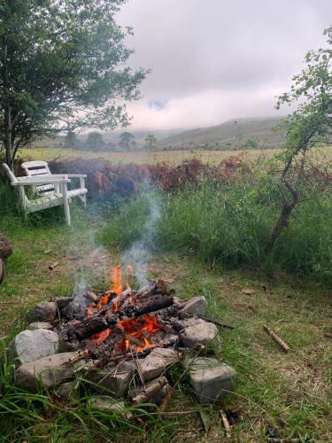 多诺赫Birkenshaw - Beautiful Shepherd’s Hut in the Highlands.的草上火,后边有长凳