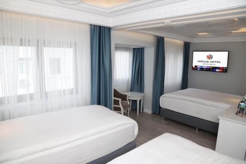 伊斯坦布尔Novus Hotel İstanbul的一间酒店客房,设有两张床和电视