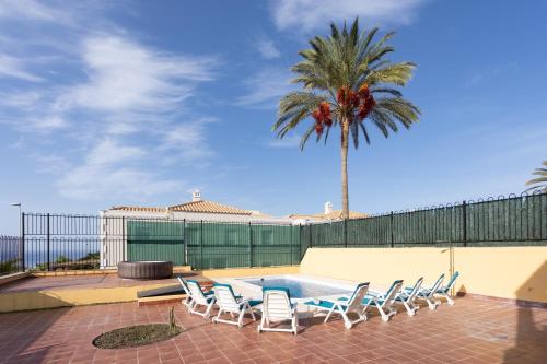 洛斯克里斯蒂亚诺斯Villa esclusiva a 1 chilometro da Playa de Los Cristianos的一个带桌椅和棕榈树的庭院