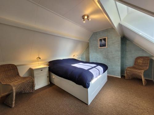 羊角村B&B Villa Giethoorn - canalview, privacy & parking的一间卧室配有一张大床和两把椅子