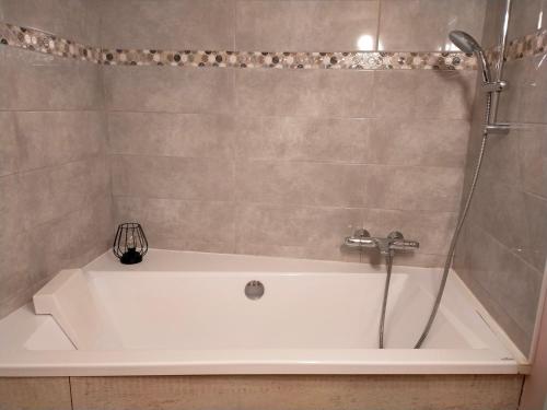 Étival-ClairefontaineLa Marmotte du Vivier的带淋浴的浴室配有白色浴缸。