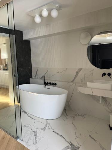 DziemianySlow Home的白色的浴室设有浴缸和水槽。