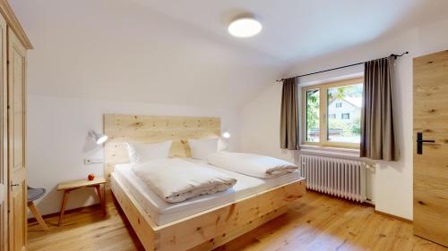 埃塔尔Fischer`s Postresidenzen Ettal的一间卧室配有一张带木制床头板的床和窗户。