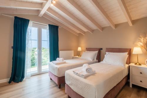 罗达Melena Premium Suites的带窗户的客房内的两张床