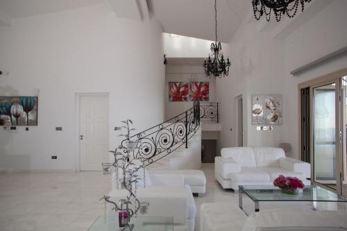 卡西卡斯Eagles Cliff Villa的客厅配有白色家具和楼梯
