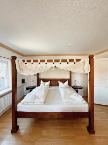 吕贝克约瑟芬公寓的卧室配有带白色枕头的天蓬床