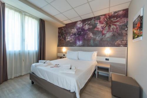 蒙卡列里达斯娜最佳品质酒店的卧室配有一张大床,墙上挂有绘画作品