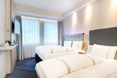 美因河畔法兰克福Premier Inn Frankfurt Westend的酒店客房设有两张床和电视。