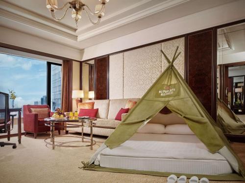 吉隆坡Shangri-La Kuala Lumpur的一间卧室配有一张床,上面有帐篷