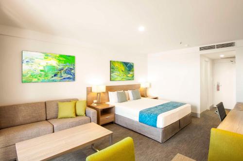 悉尼悉尼美罗阿斯皮尔酒店的酒店客房,配有床和沙发