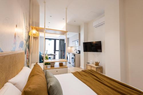 瓦伦西亚FLORIT FLATS - The Green Apartments的一间带白色床的卧室和一间厨房