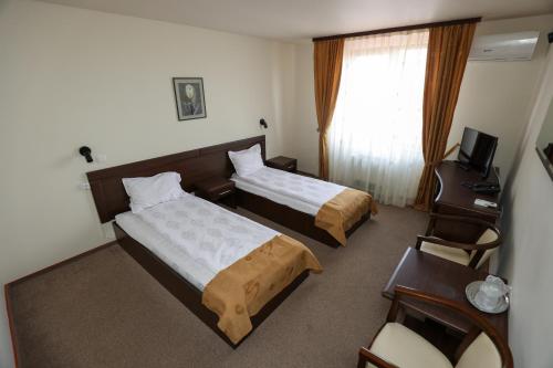 雷希察Hotel Dusan si Fiul Resita Sud的酒店客房配有两张床和一张书桌