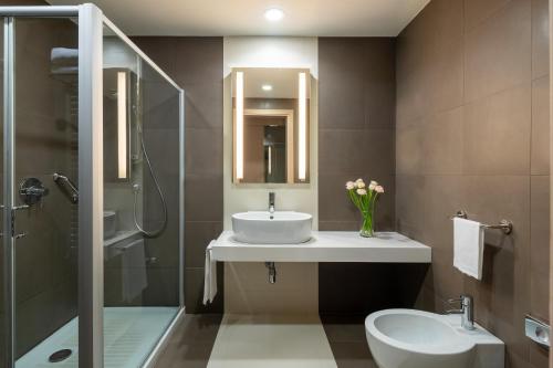 萨韦纳河畔圣拉扎罗UNAHOTELS Bologna San Lazzaro的一间带水槽、卫生间和淋浴的浴室
