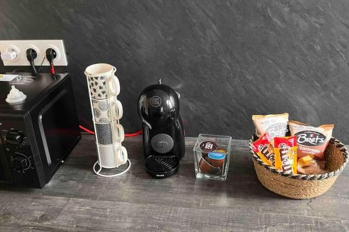 博韦Appartement f2 Résidence Nassau的咖啡壶和微波炉旁的小吃篮