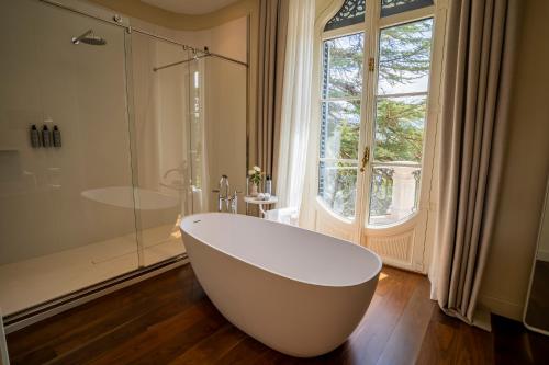 博吕尔Torre del Remei的带窗户的浴室内的白色浴缸