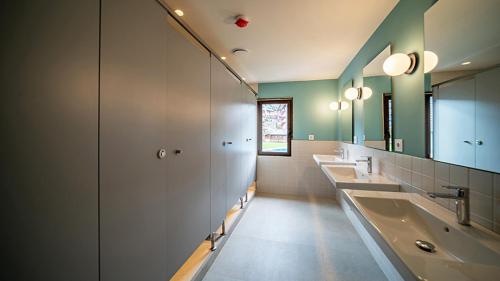 萨拉尔杜Aran Hostel的浴室设有3个水槽和一排镜子