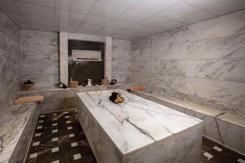 赫尔格达伊贝罗泰尔马卡迪海滩酒店的一间带大型大理石浴缸和窗户的浴室