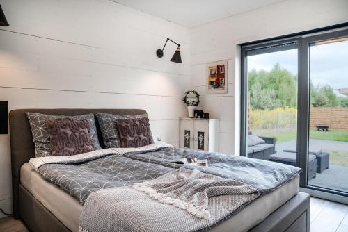 科沃布热格Domek hot tub jacuzzi Chillout的一间卧室设有一张床和一个滑动玻璃门